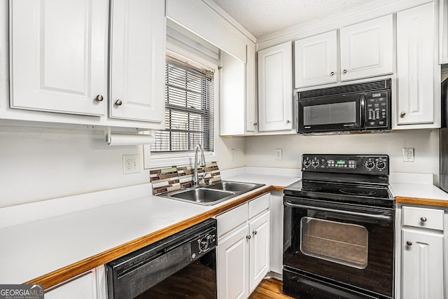 kitchen featuring black appliances, light wood-type flooring, white cabinetry, and sink