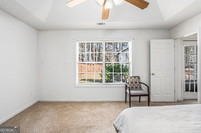 carpeted bedroom featuring ceiling fan and a raised ceiling