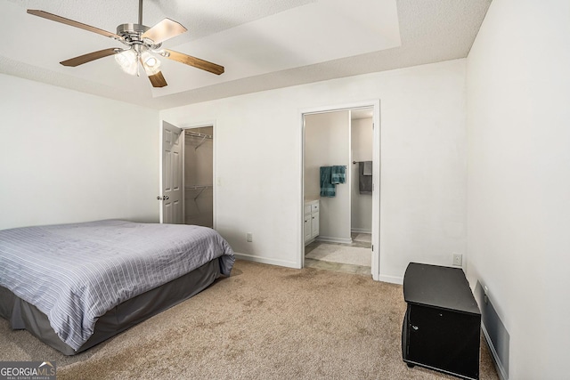 carpeted bedroom featuring ensuite bath, a textured ceiling, ceiling fan, a spacious closet, and a closet