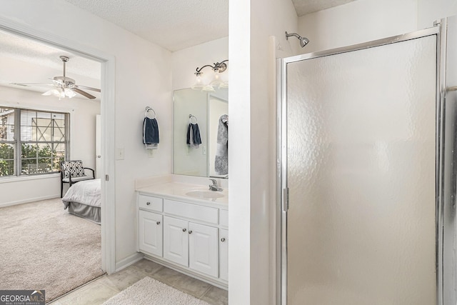 bathroom featuring vanity, a textured ceiling, ceiling fan, and a shower with shower door