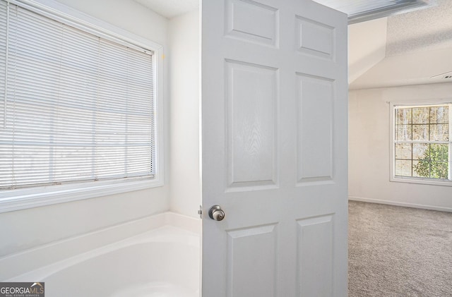 bathroom with a bathing tub and a textured ceiling