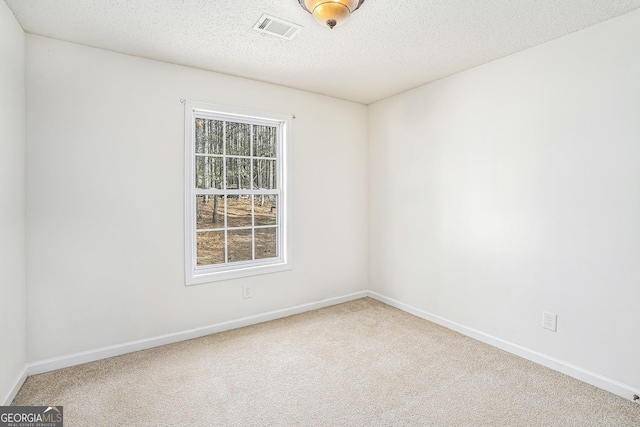 spare room with carpet and a textured ceiling