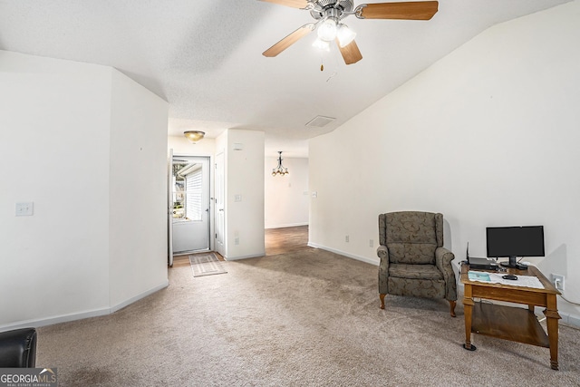 sitting room featuring carpet, ceiling fan with notable chandelier, and vaulted ceiling