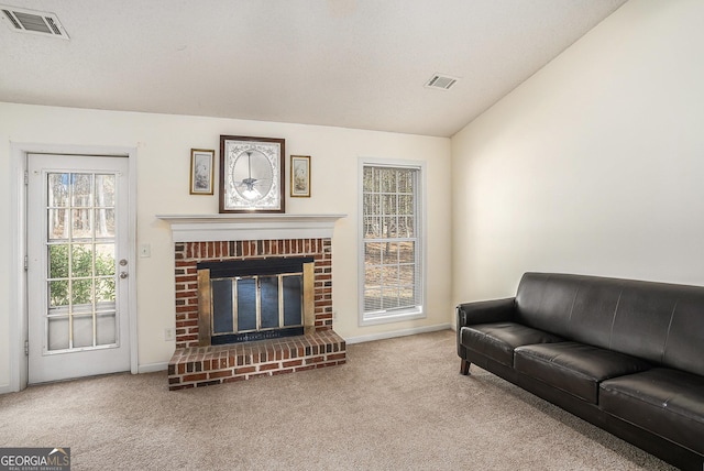 living room featuring carpet, vaulted ceiling, and a fireplace