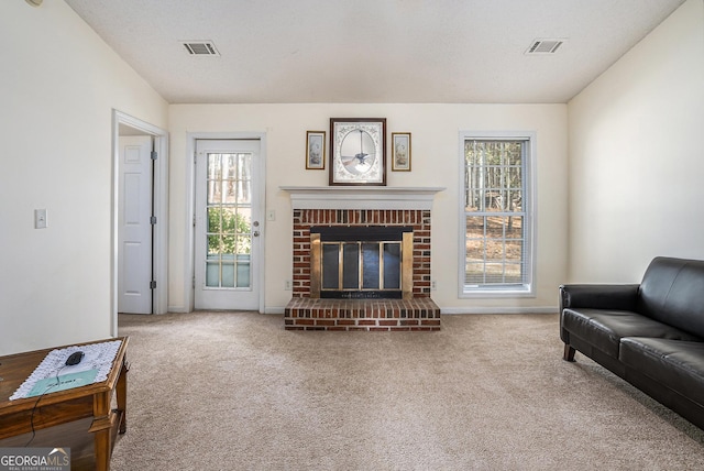 living room with lofted ceiling, carpet floors, a brick fireplace, and a healthy amount of sunlight