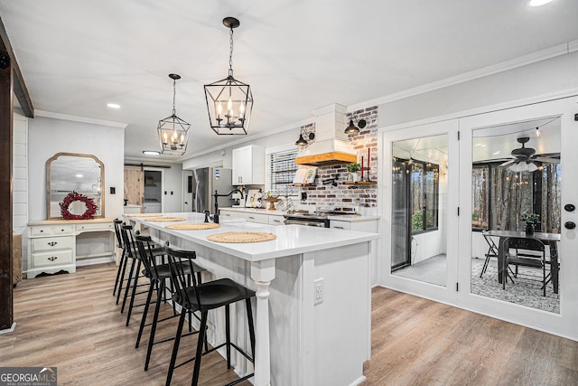 kitchen featuring stainless steel appliances, white cabinetry, and crown molding