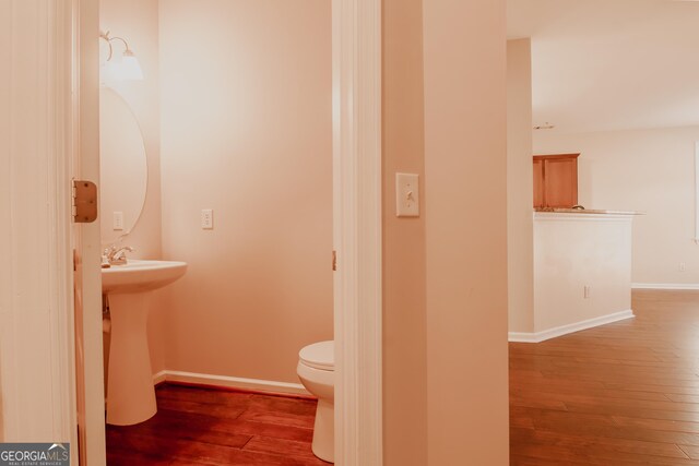 bathroom featuring wood-type flooring, sink, and toilet