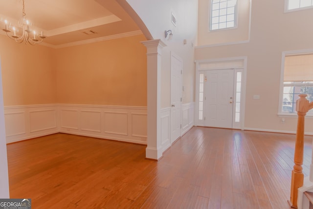 entryway featuring hardwood / wood-style flooring, plenty of natural light, and ornate columns