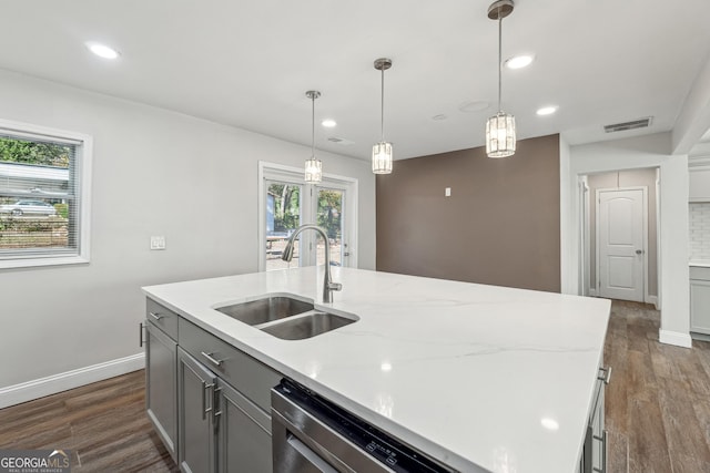 kitchen with pendant lighting, an island with sink, dark hardwood / wood-style floors, and sink