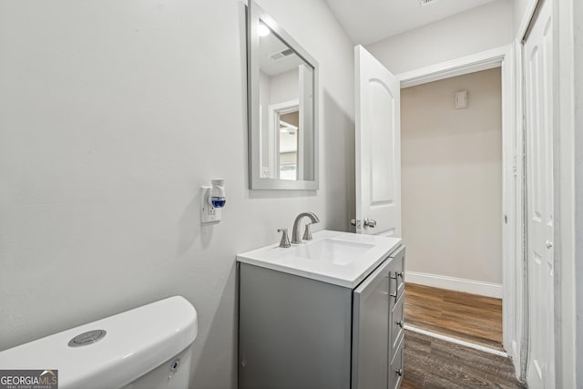 bathroom with vanity, wood-type flooring, and toilet