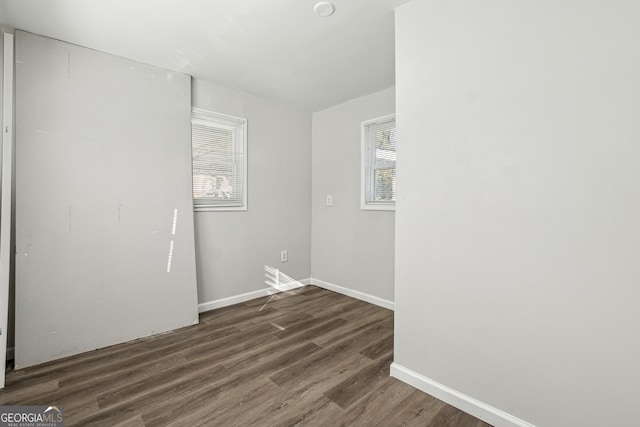 unfurnished room featuring a wealth of natural light and dark hardwood / wood-style floors