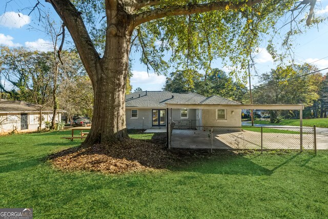 rear view of property with a lawn and a patio area