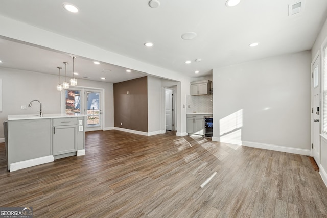 kitchen featuring pendant lighting, gray cabinets, hardwood / wood-style floors, and tasteful backsplash