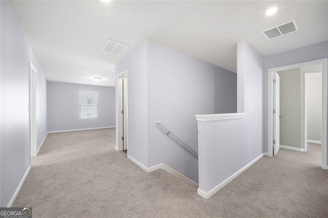 hallway featuring light colored carpet