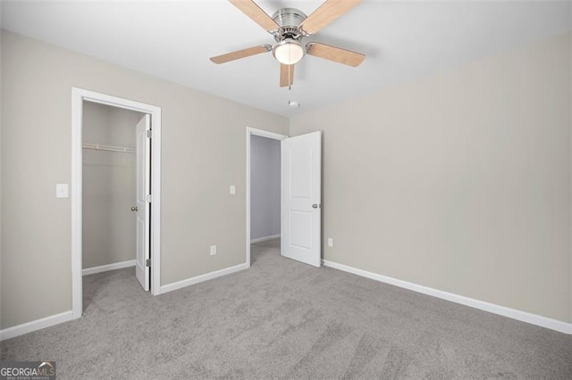 unfurnished bedroom featuring a walk in closet, ceiling fan, a closet, and light carpet