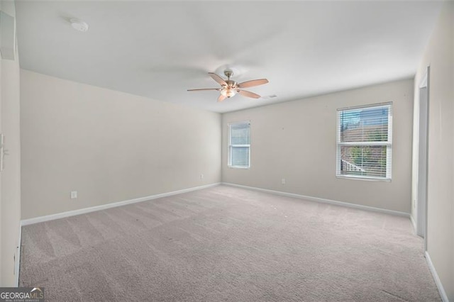 carpeted spare room with ceiling fan