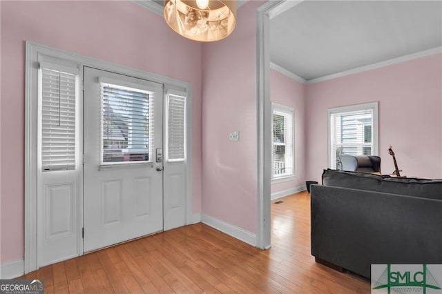 foyer featuring light wood-type flooring and ornamental molding