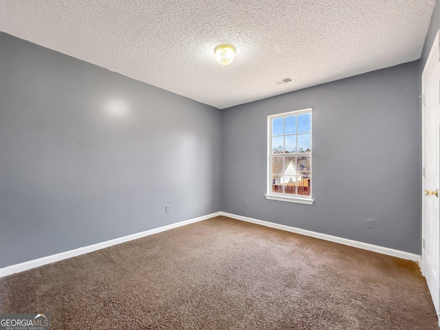 carpeted empty room with a textured ceiling