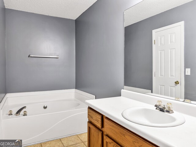 bathroom featuring a washtub, vanity, and a textured ceiling