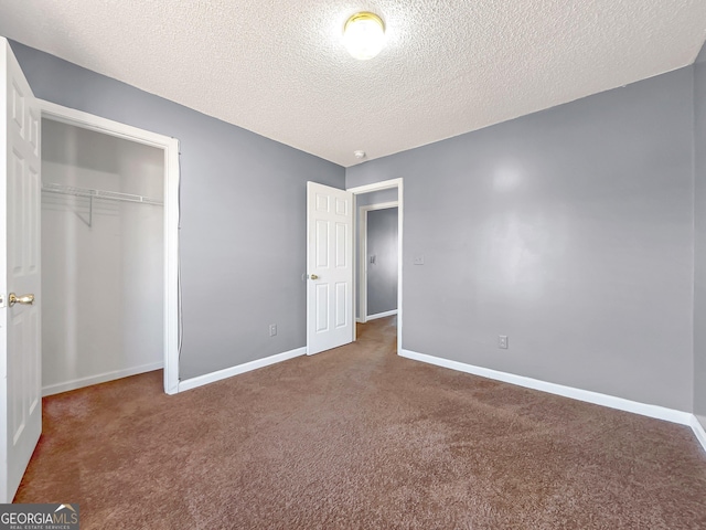 unfurnished bedroom featuring carpet flooring, a textured ceiling, and a closet