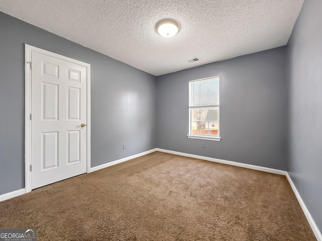 unfurnished room with carpet floors and a textured ceiling