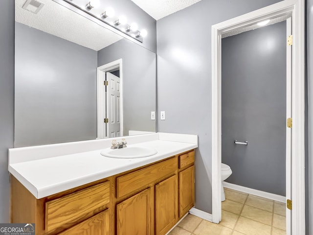 bathroom featuring tile patterned floors, vanity, toilet, and a textured ceiling