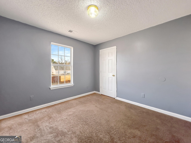 carpeted empty room with a textured ceiling