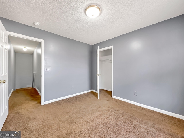 unfurnished bedroom featuring a closet, carpet floors, and a textured ceiling