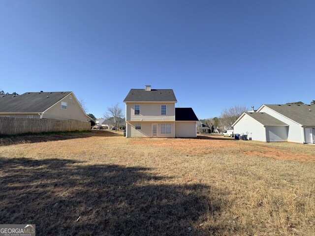 back of house featuring a lawn