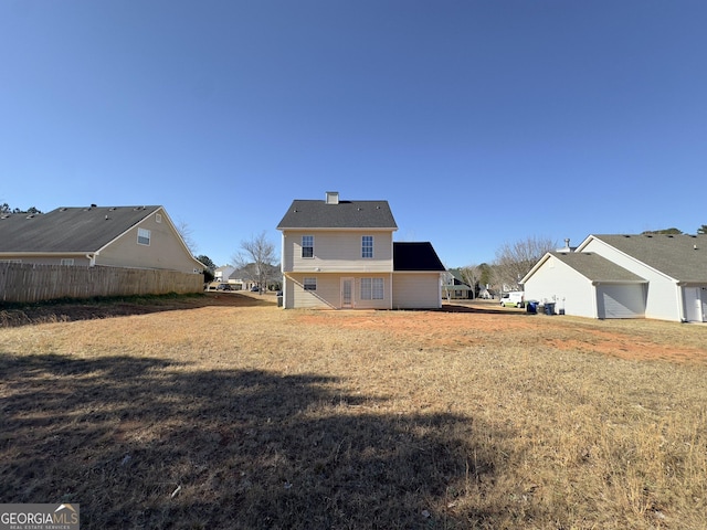 rear view of property featuring a lawn