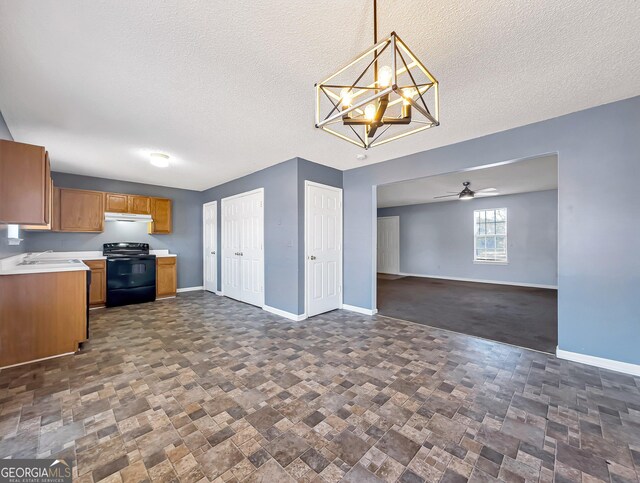 kitchen featuring ceiling fan with notable chandelier, a textured ceiling, sink, pendant lighting, and electric range