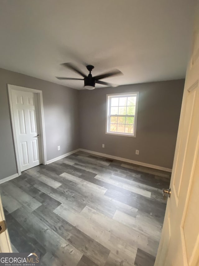 empty room featuring ceiling fan and dark wood-type flooring