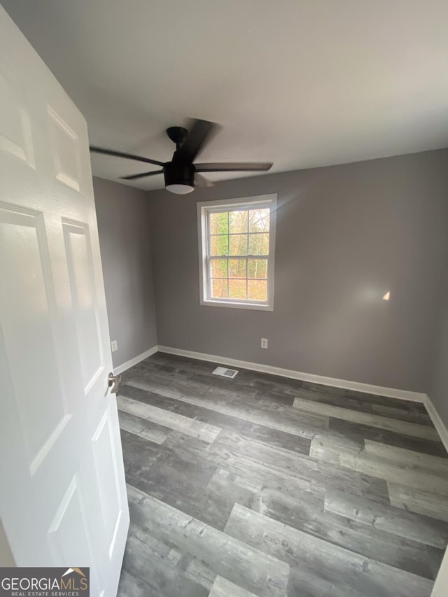 spare room featuring ceiling fan and dark hardwood / wood-style floors