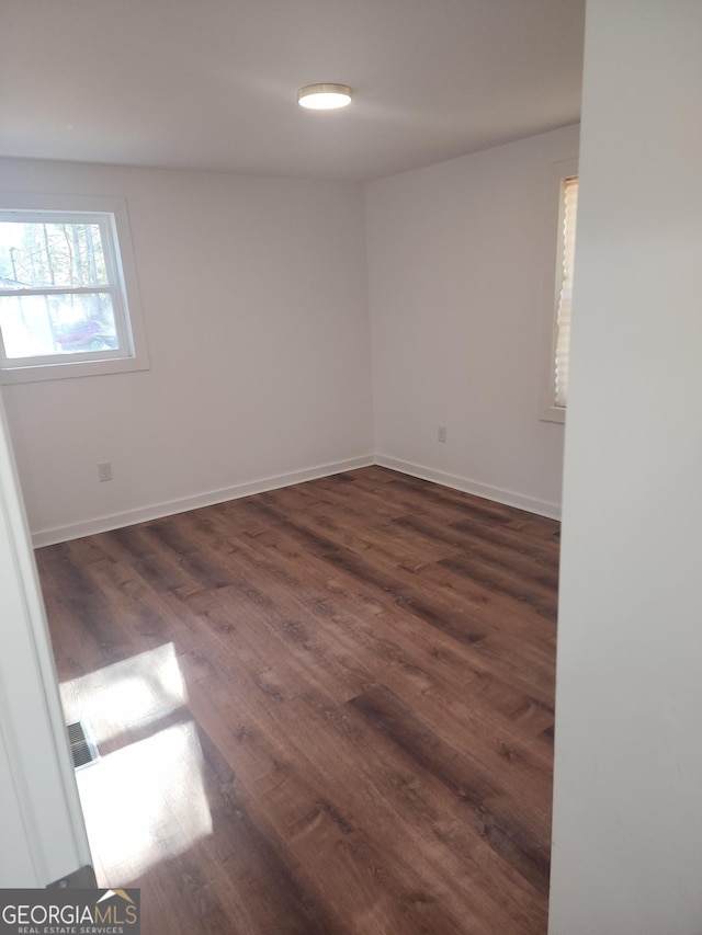 unfurnished room featuring dark wood-type flooring