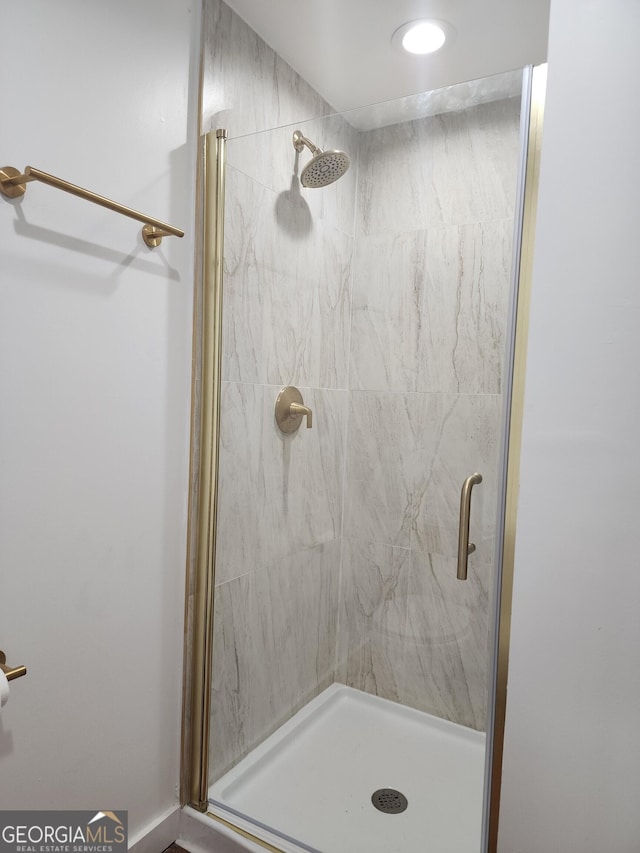 bathroom featuring a shower with door