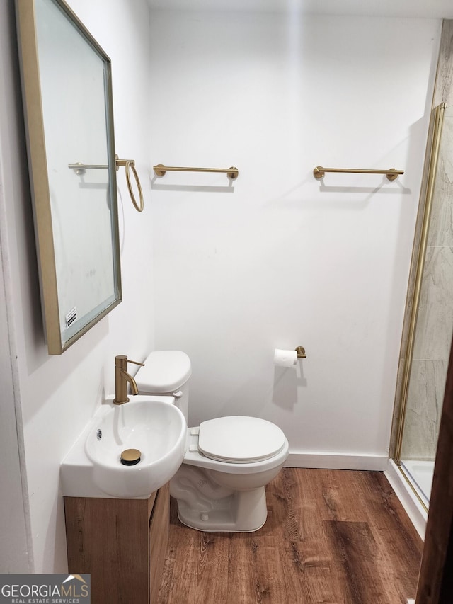 bathroom featuring sink, walk in shower, toilet, and wood-type flooring