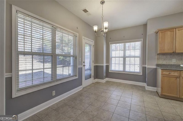 unfurnished dining area with light tile patterned flooring and a notable chandelier