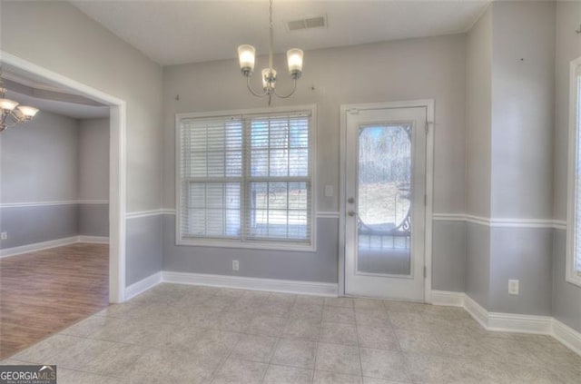 doorway featuring light tile patterned floors and a chandelier