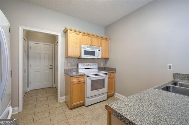 kitchen featuring decorative backsplash, light brown cabinetry, white appliances, sink, and light tile patterned floors