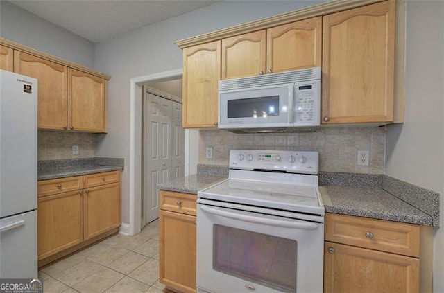 kitchen with light tile patterned flooring, light brown cabinets, white appliances, and backsplash