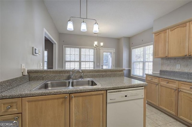 kitchen featuring dishwasher, backsplash, an inviting chandelier, sink, and light tile patterned floors