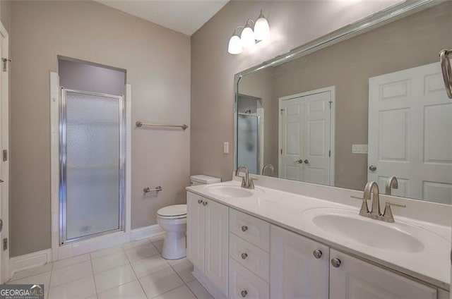 bathroom featuring tile patterned floors, toilet, vanity, and walk in shower