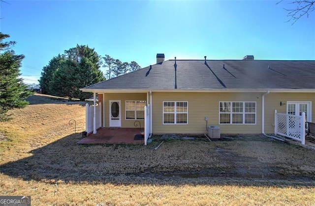 rear view of property with central AC unit and a patio