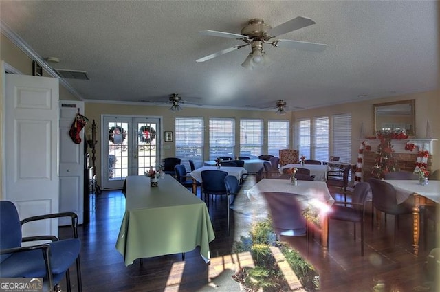 living room featuring french doors, a textured ceiling, dark wood-type flooring, and ornamental molding