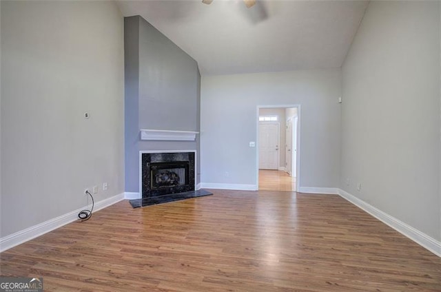 unfurnished living room featuring a fireplace, hardwood / wood-style flooring, ceiling fan, and lofted ceiling