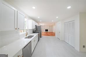 kitchen featuring stainless steel dishwasher, white cabinetry, sink, and electric stove