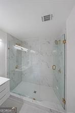 bathroom with a shower with door and vanity