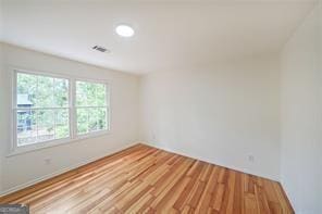 empty room with light hardwood / wood-style floors and vaulted ceiling