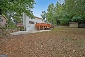 view of yard with a patio, a deck, and a storage unit