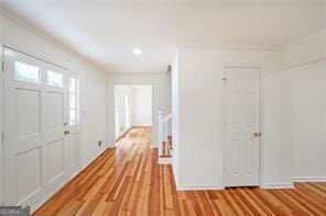 entryway with light hardwood / wood-style floors and ornamental molding